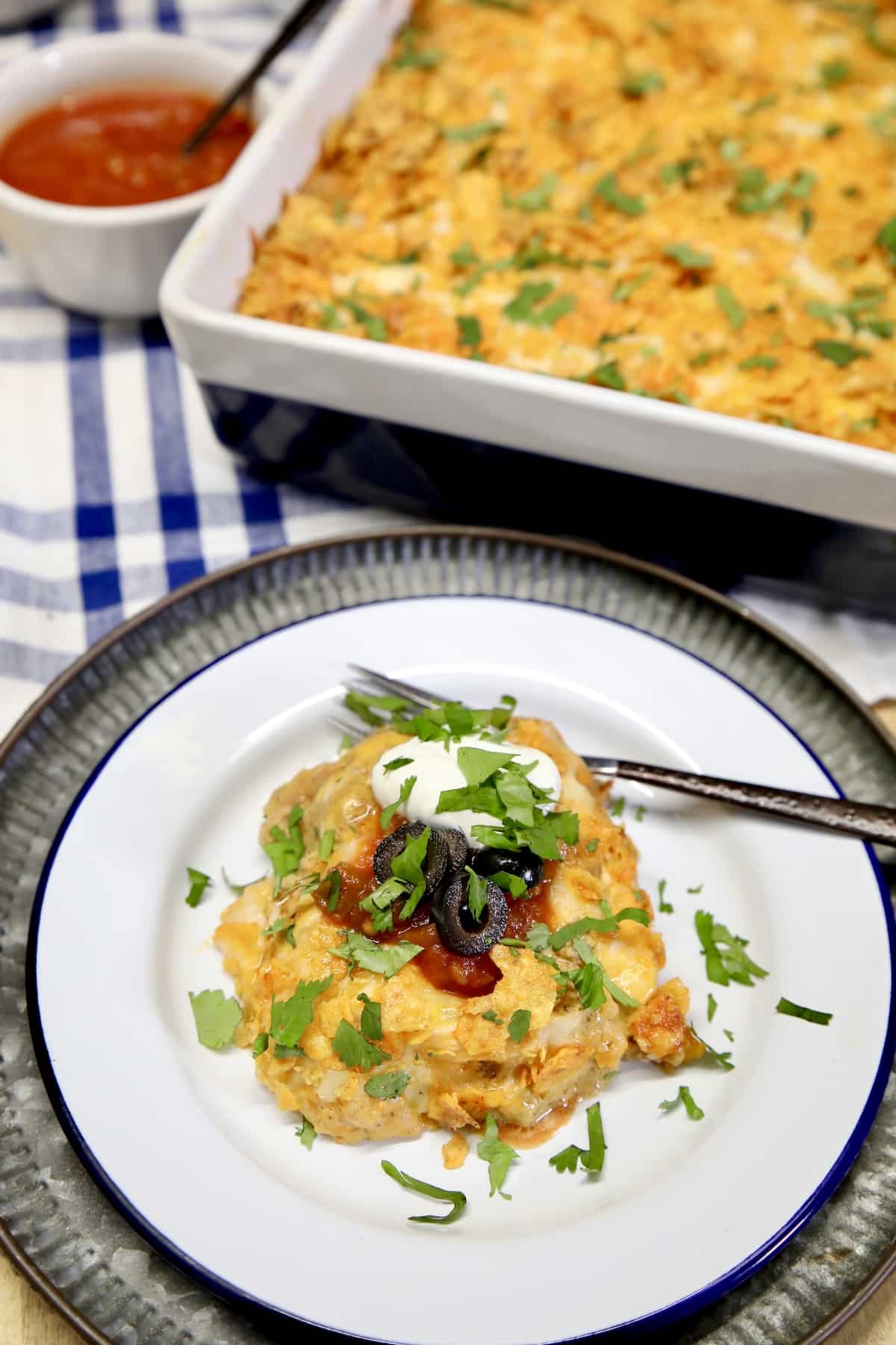 Chicken burrito casserole with sour cream on a plate.