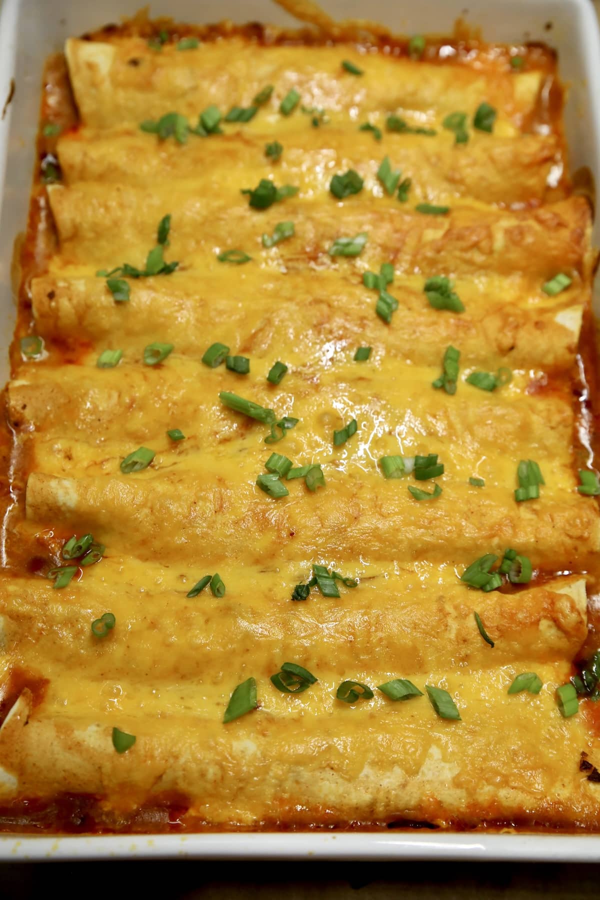 Enchilada ground beef casserole. Enchilada casserole with green onion garnish.