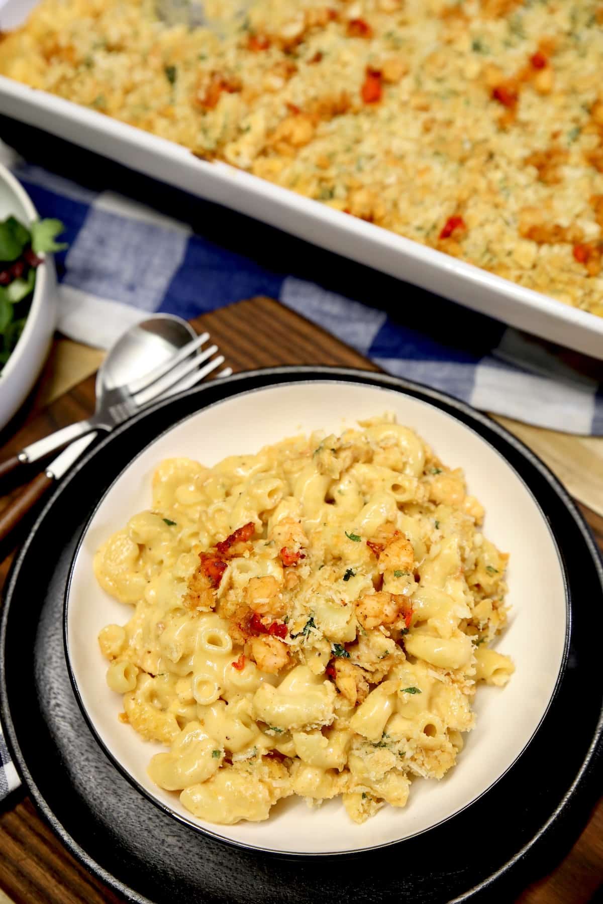 Bowl of mac and cheese, casserole in background.