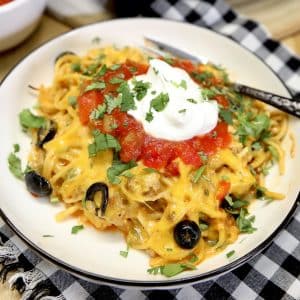 Plate of taco spaghetti with sour cream and salsa.