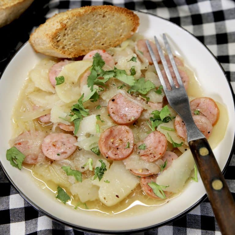 Plate of sausage and potatoes with onions.