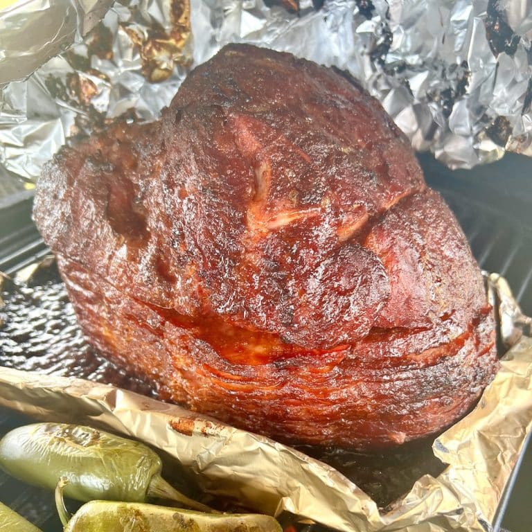 Blackberry glazed ham on a grill.
