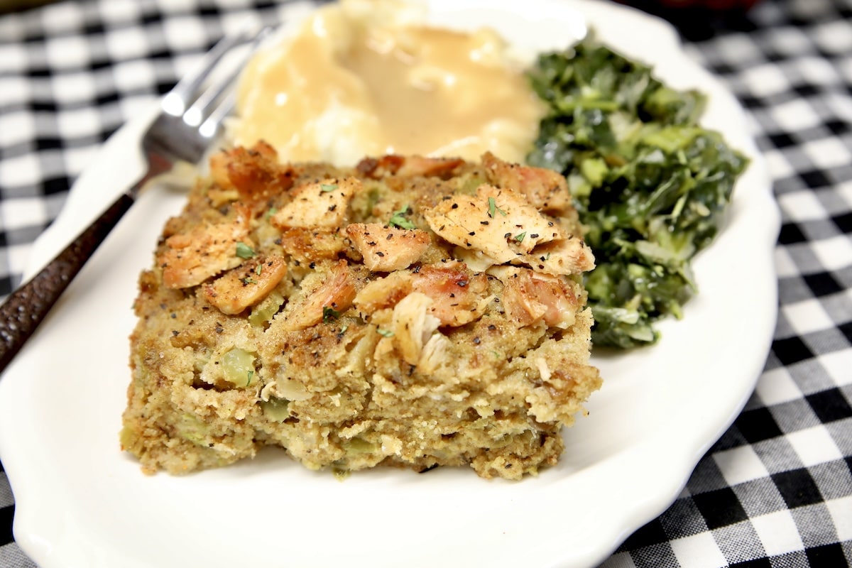 Dressing on a plate with mashed potatoes, gravy and greens.