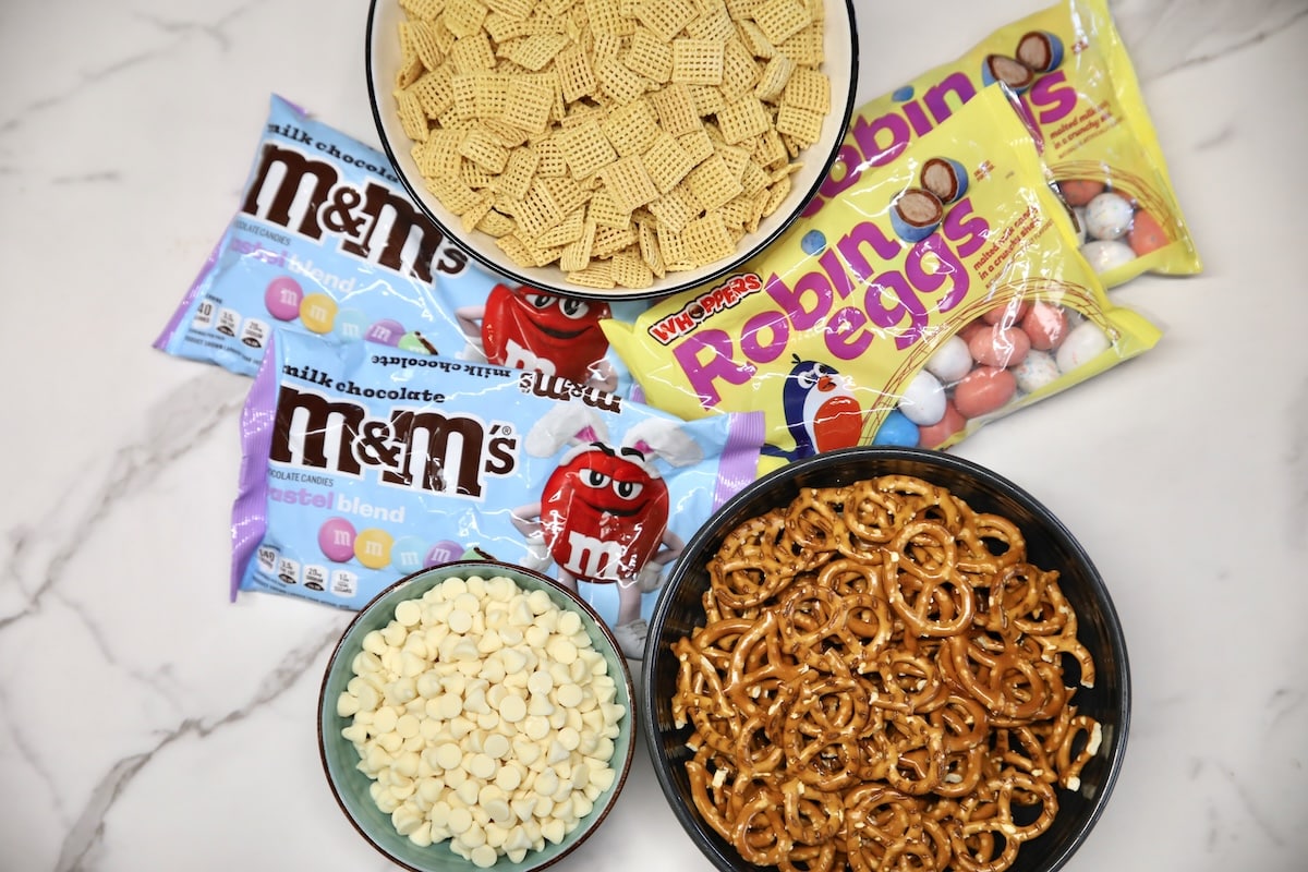 Ingredients for bunny bait: chex cereal, white chocolate chips, m&ms, robin's eggs.