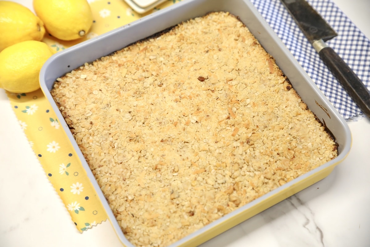 Pan of dessert bars, whole lemons, knife.