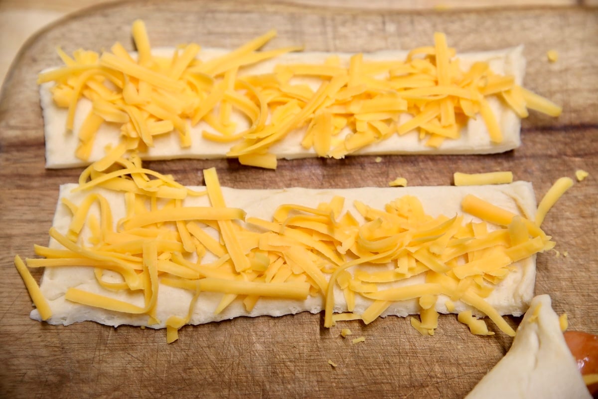 Shredded cheese on crescent dough rectangles.