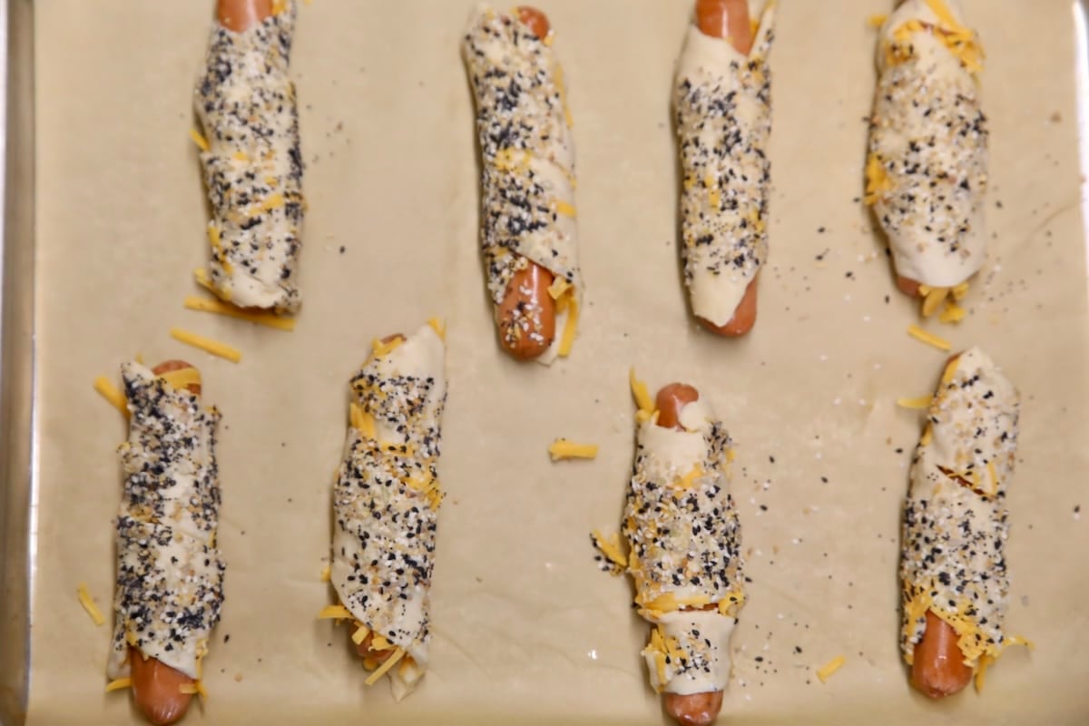 Crescent hot dogs on a parchment lined baking sheet.