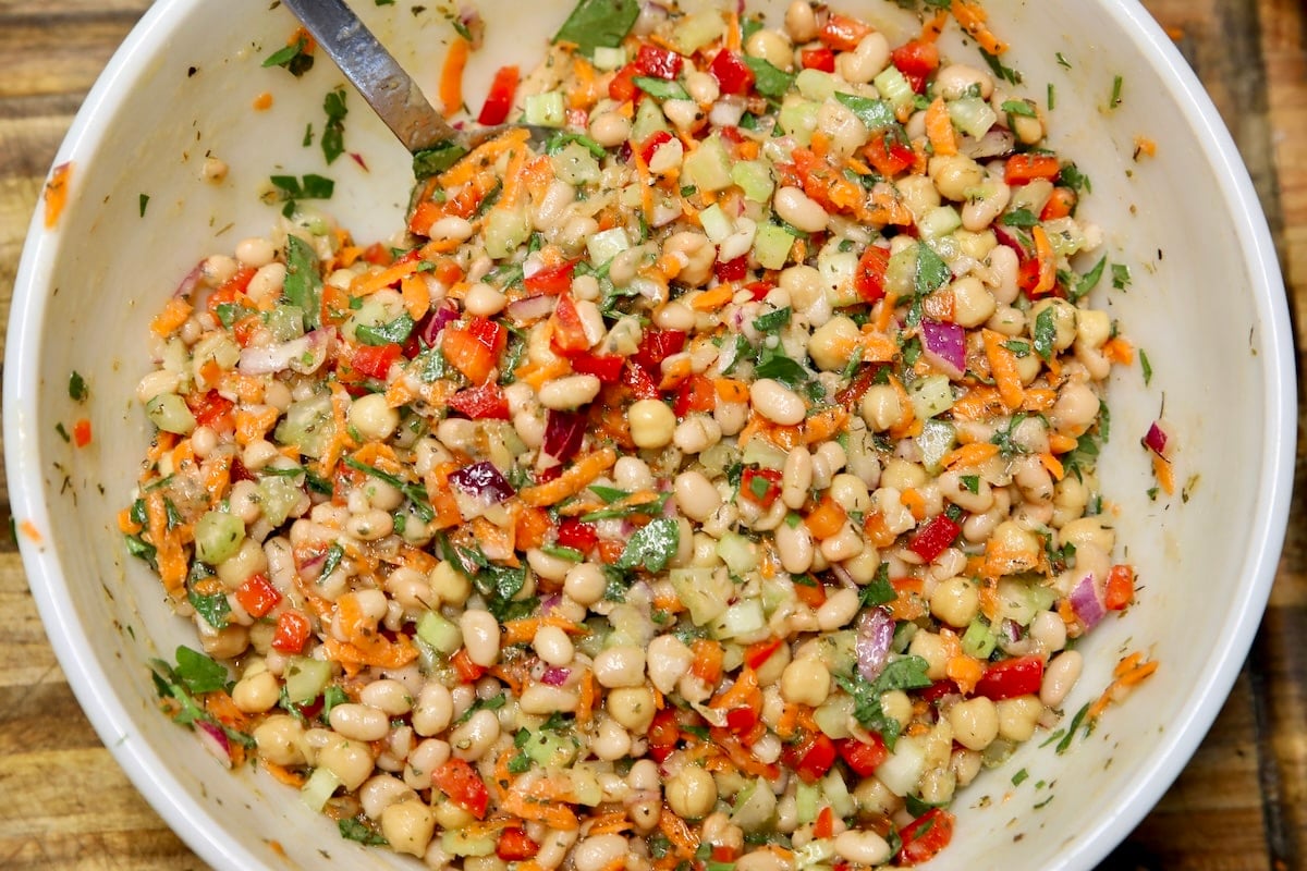 White bean salad in a bowl with herbs and vegetables.