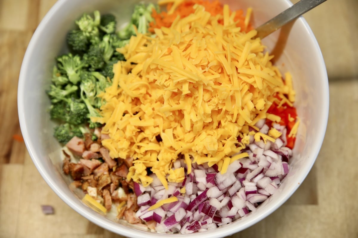 Bowl with chopped vegetables, ham, cheese.