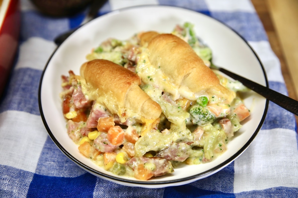 Pot pie with ham and vegetable filling, crescent rolls.