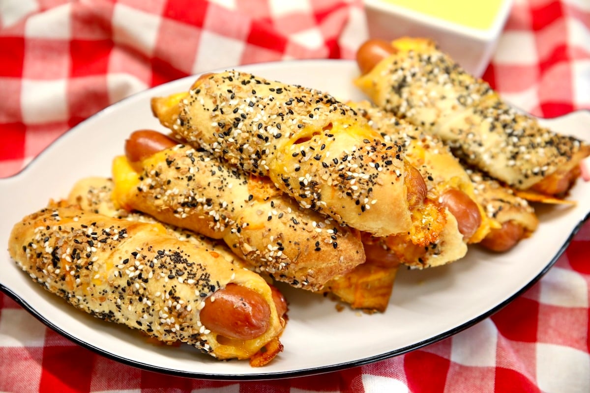 Platter of cheesy pigs in a blanket hot dogs.