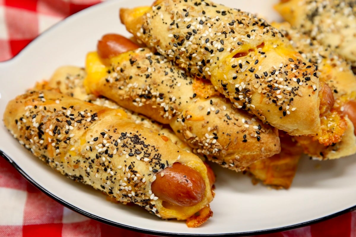 Pigs in a blanket with crescent dough and everything bagel seasoning on a platter.