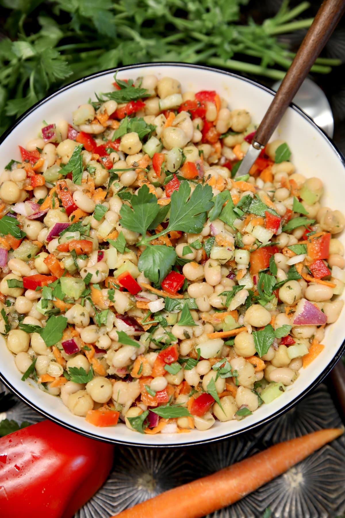 Bowl of salad with white beans, vegetables and herb dressing.