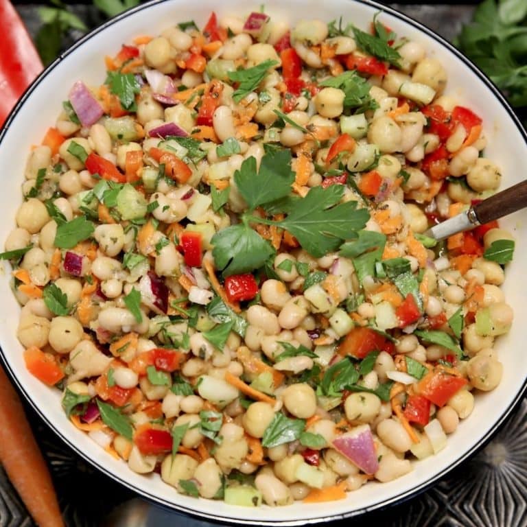 Bowl of white bean salad with s spoon.