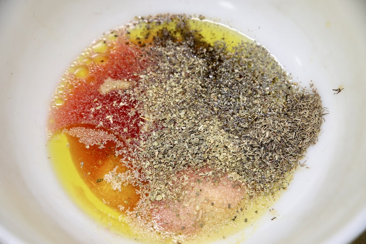 Dressing with dried herbs in a bowl - not mixed.