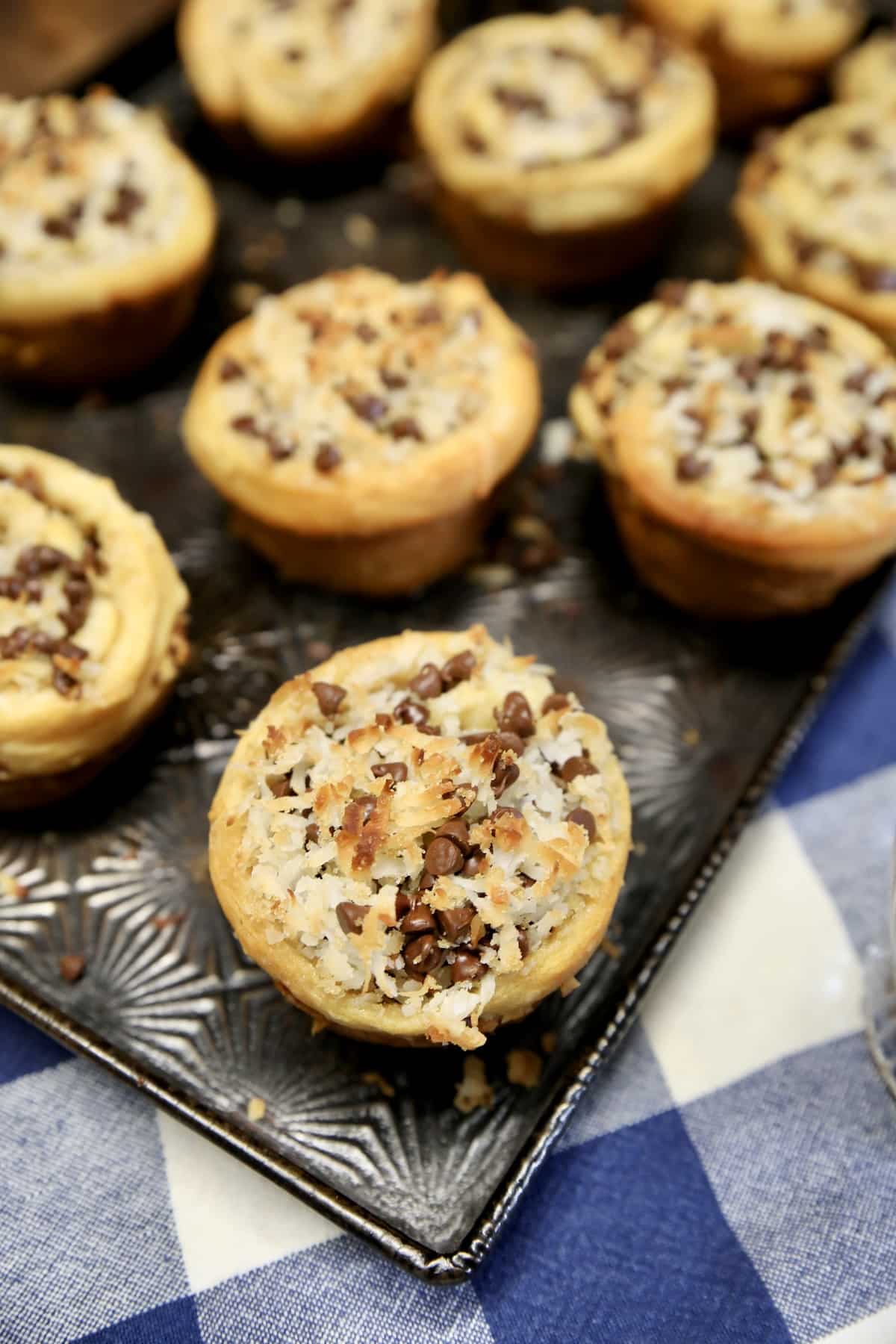 Coconut chocolate chip croissant muffins on a tray.