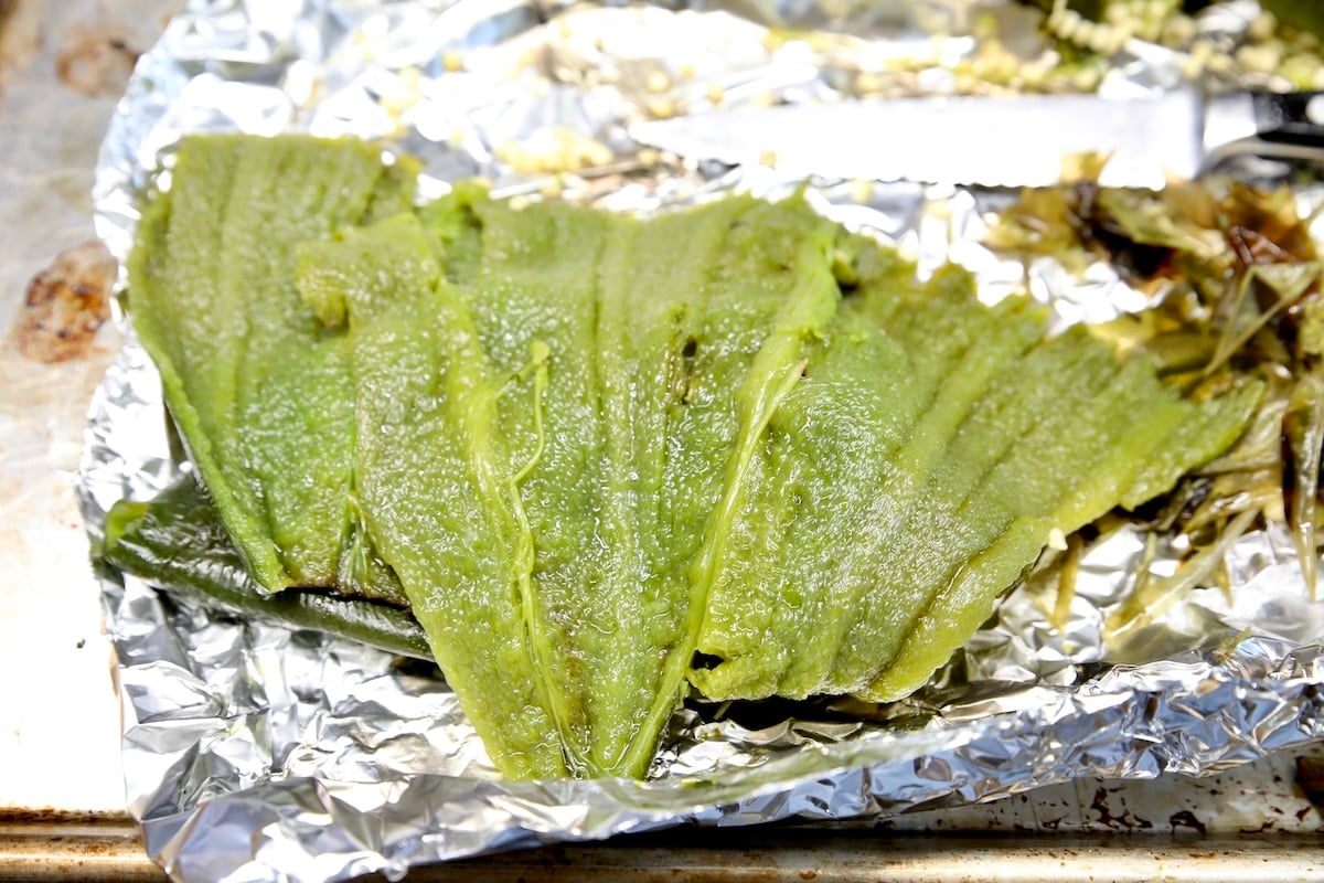 Poblano peppers roasted and seeded on foil.