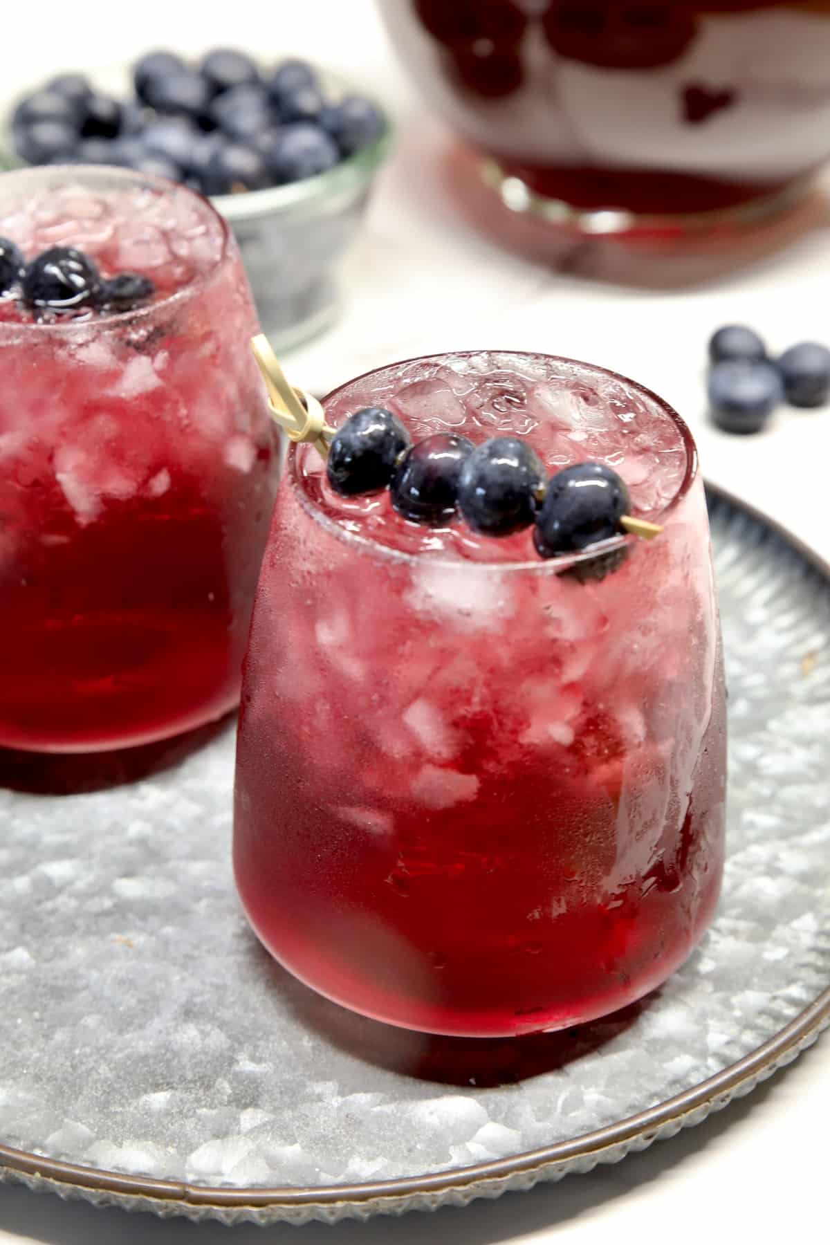 2 glasses of blueberry punch on a platter.