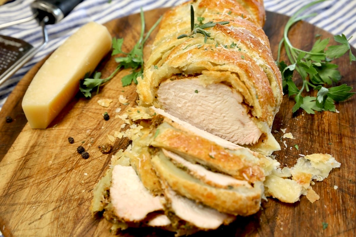 Chicken Wellington sliced on cutting board.