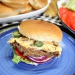 Jalapeno popper burger on a blue plate.