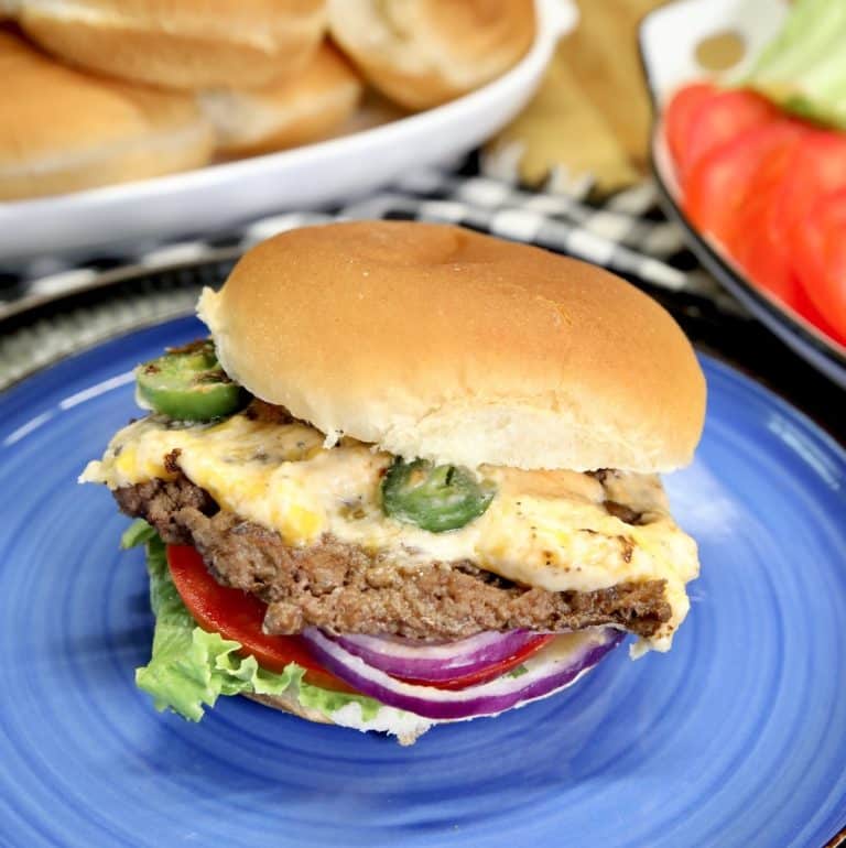 Jalapeno popper burger on a blue plate.