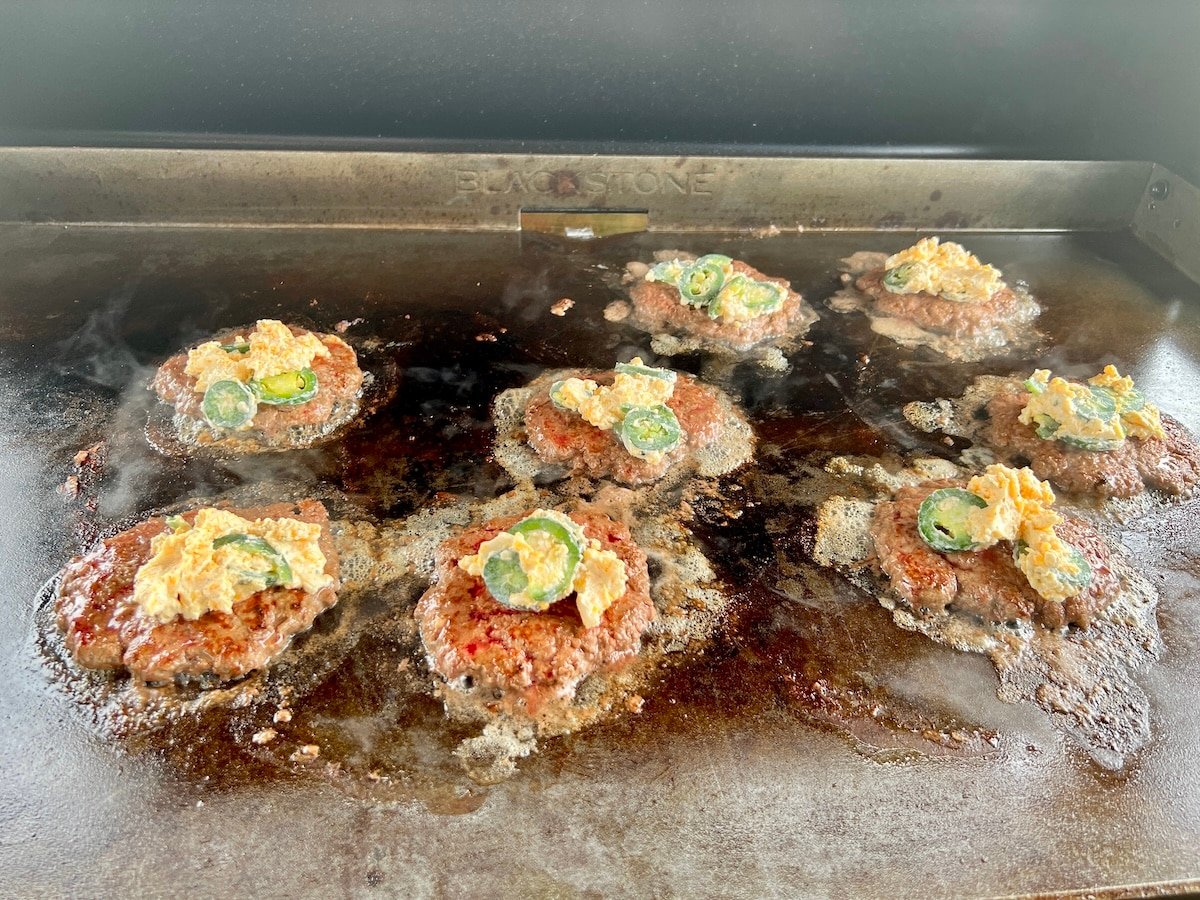 Cooking jalalpeno popper burgers on griddle.