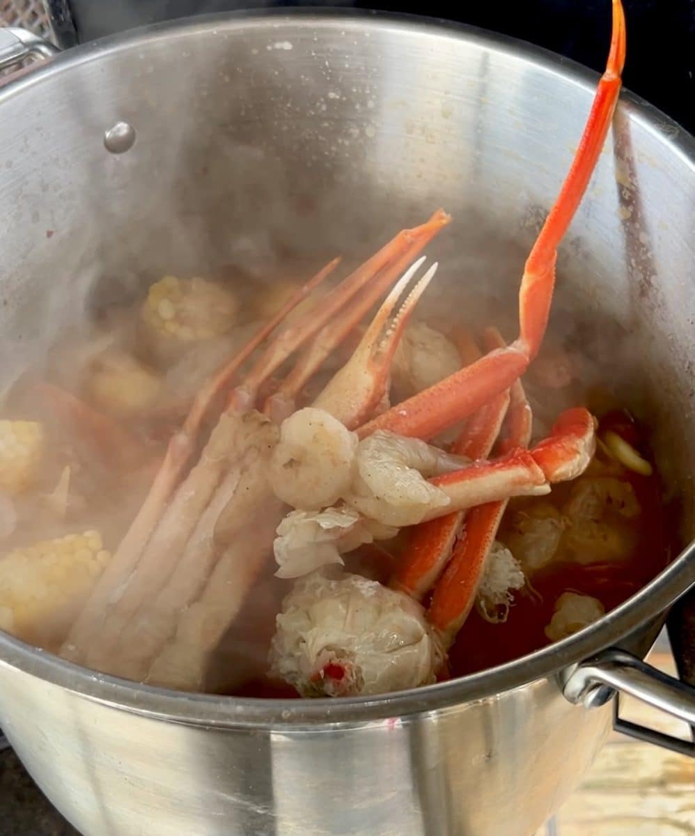 Adding seafood to low country boil.