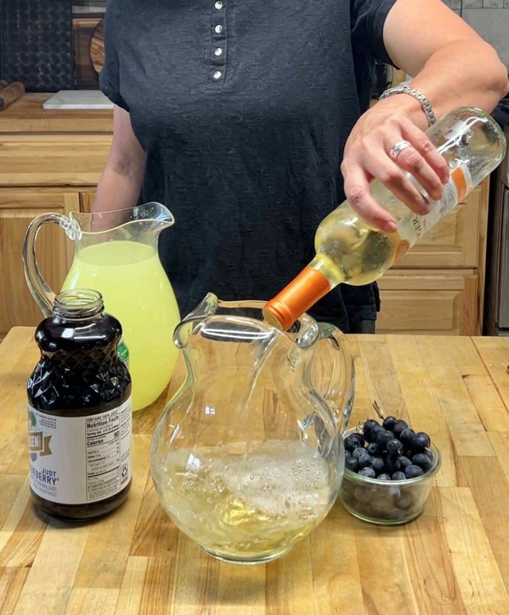 Pouring wine into a pitcher for punch.