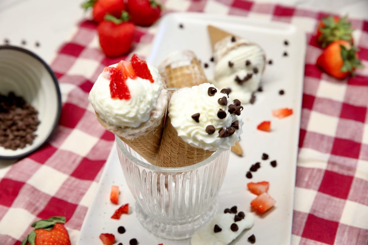 Frozen cheesecake cones make ahead dessert. Frozen cheesecake cones topped with strawberries & chocolate chips.