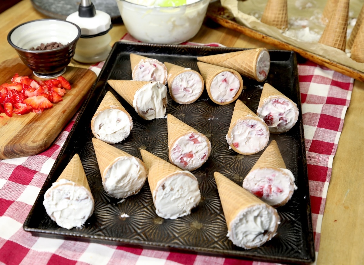 Cookie sheet with frozen cheesecake cones.