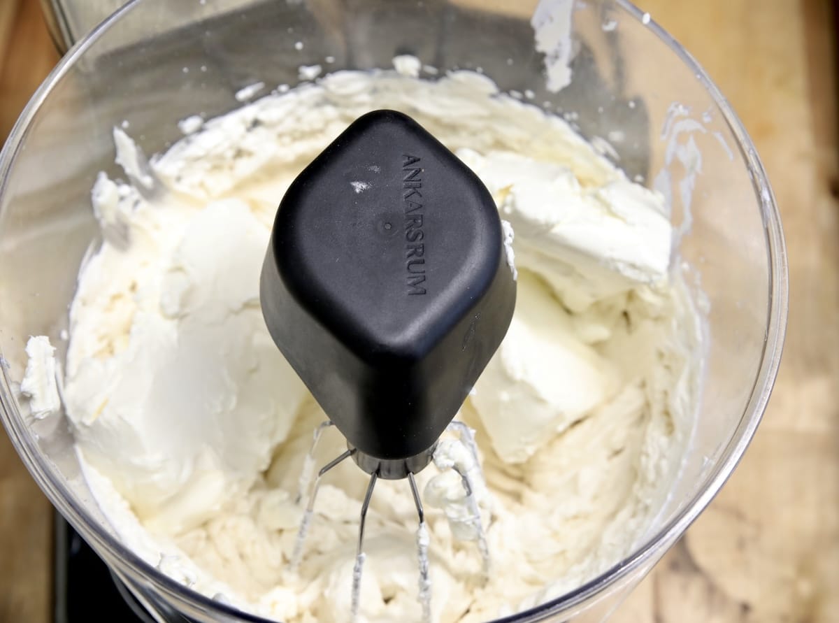 Mixer bowl with cream cheese and whipped cream.