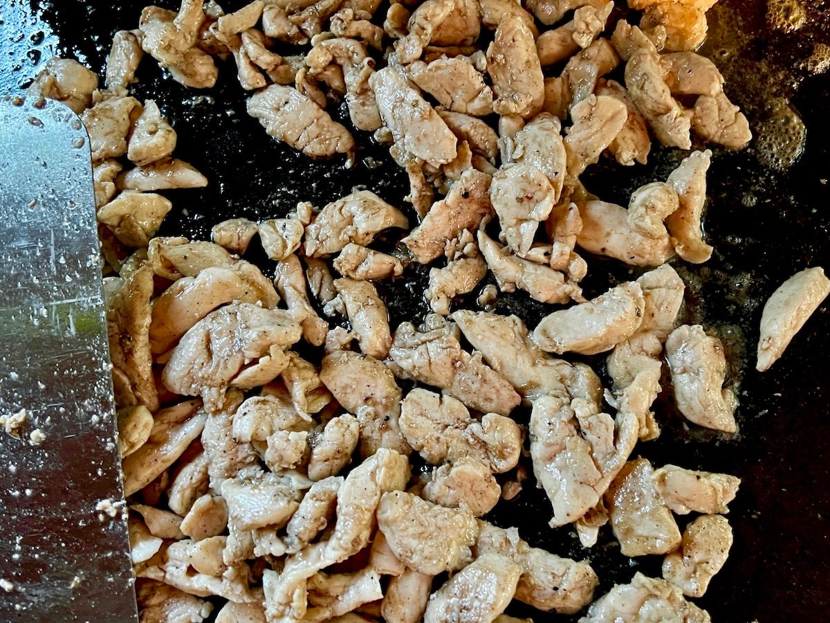 Sliced chicken on a griddle.