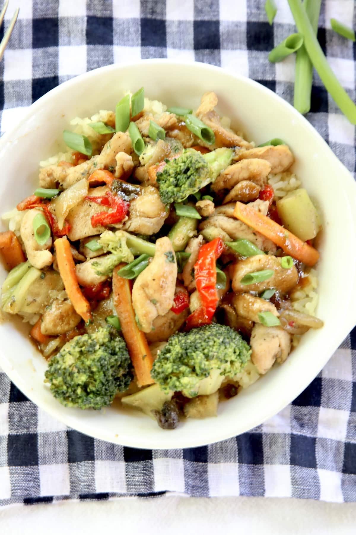 Honey garlic chicken stir fry in a bowl on check napkin.