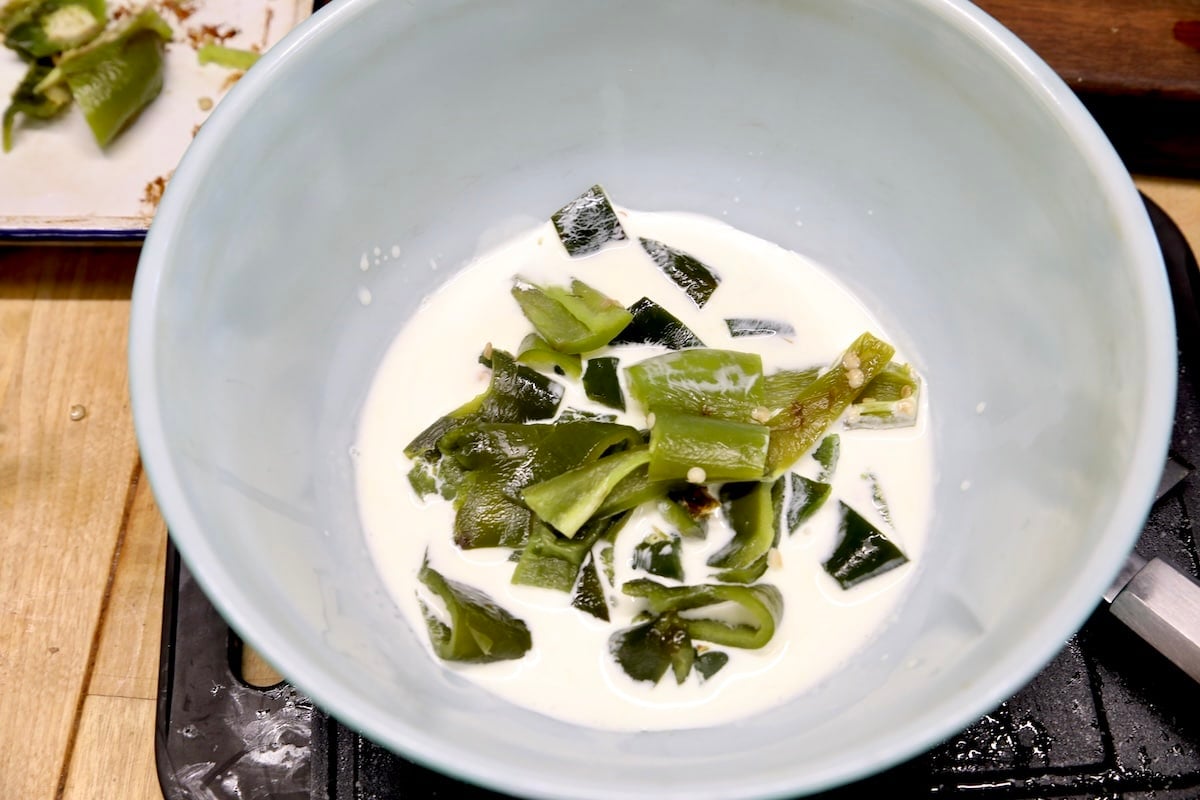 Cream in a bowl with chopped poblanos.