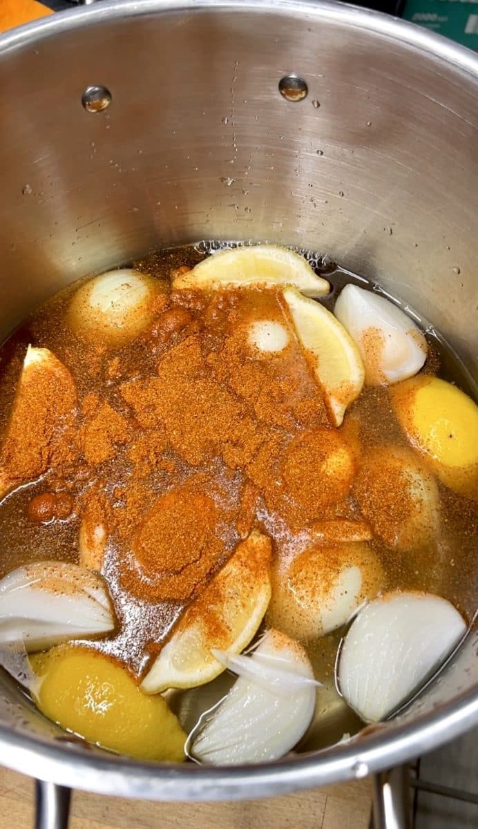 Lemons, onions, old bay seasoning in stock pot broth.