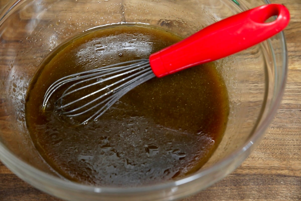 Honey garlic sauce for stir fry in a bowl with whisk.