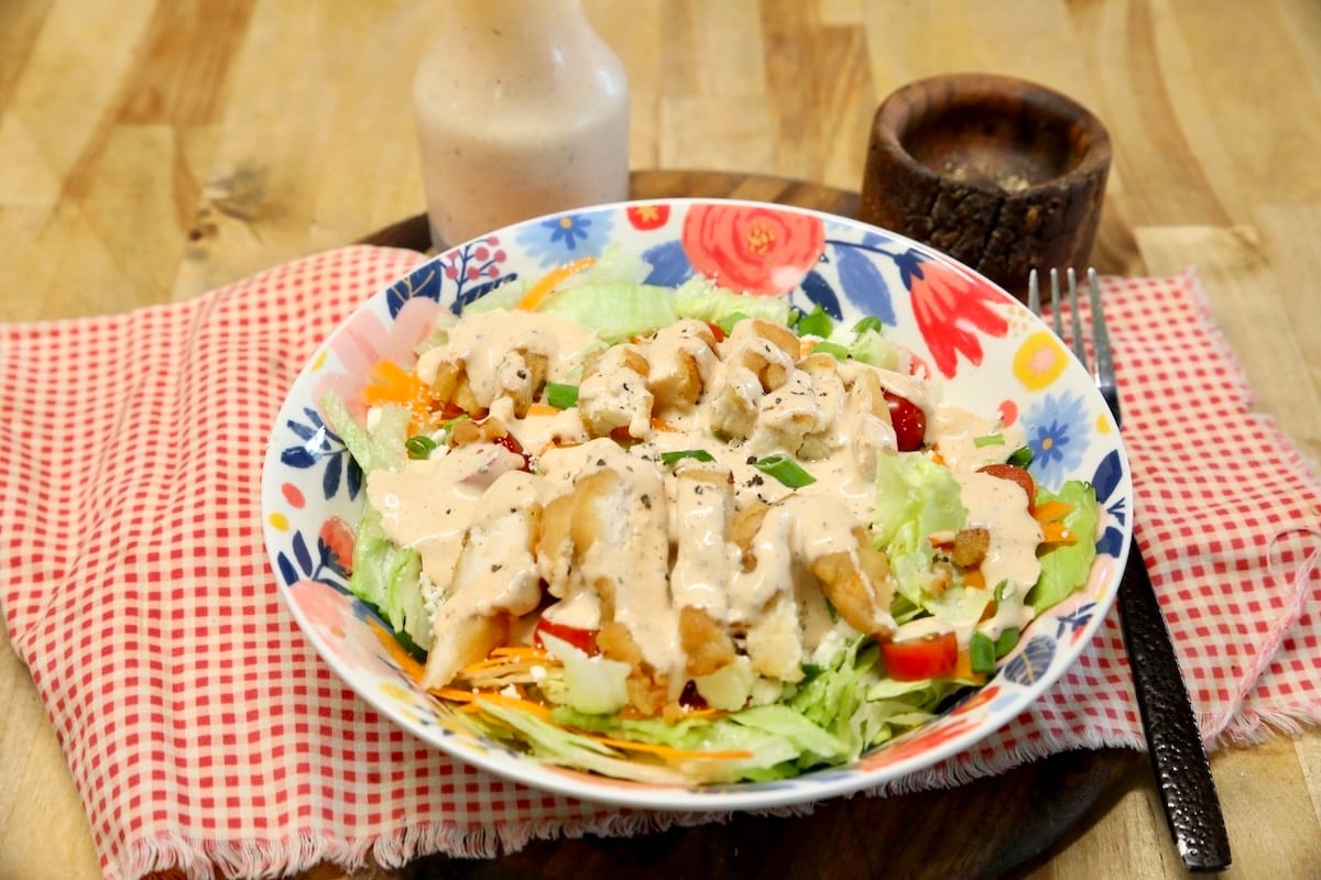 Salad with chicken and bbq ranch dressing in a bowl.