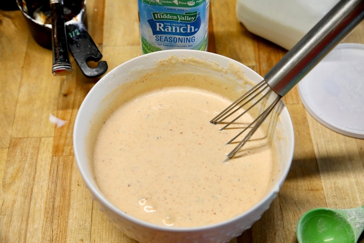 Bowl of BBQ Ranch dressing with whisk.
