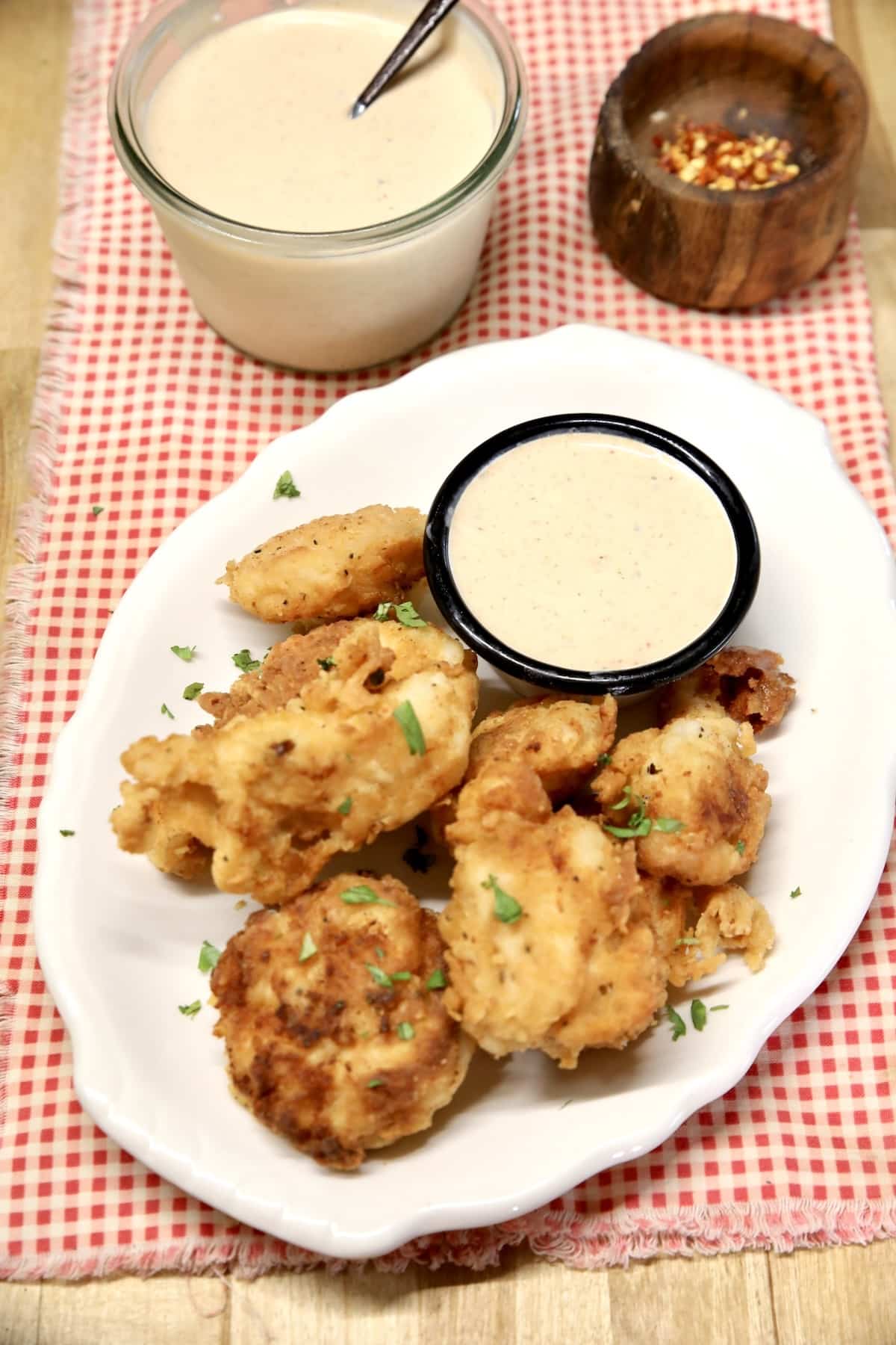 BBQ ranch in a sauce cup with platter of chicken nuggets.