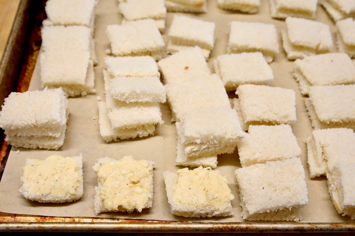 Making cheese dreams mini sandwiches on sheet pan.