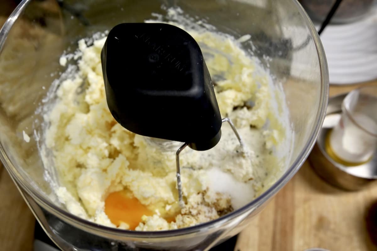 Egg and seasonings in bowl of butter and cheese.
