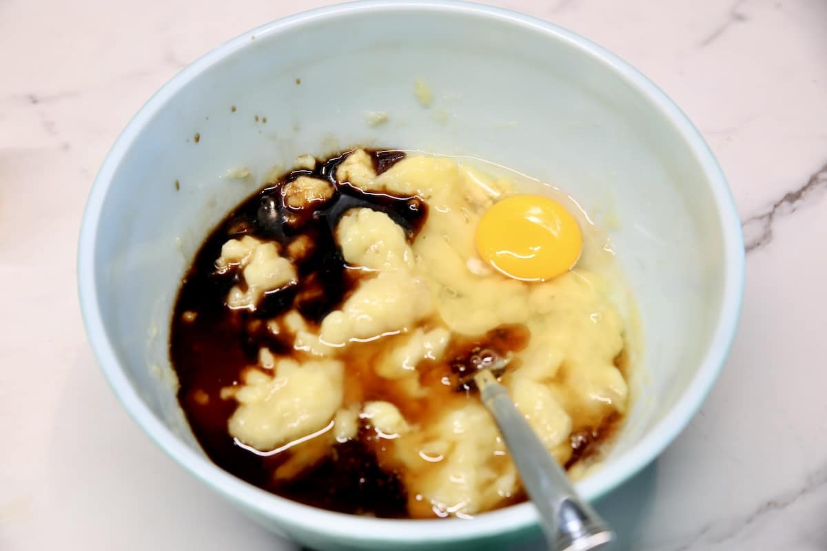Bowl of mashed bananas, vanilla, egg, olive oil.