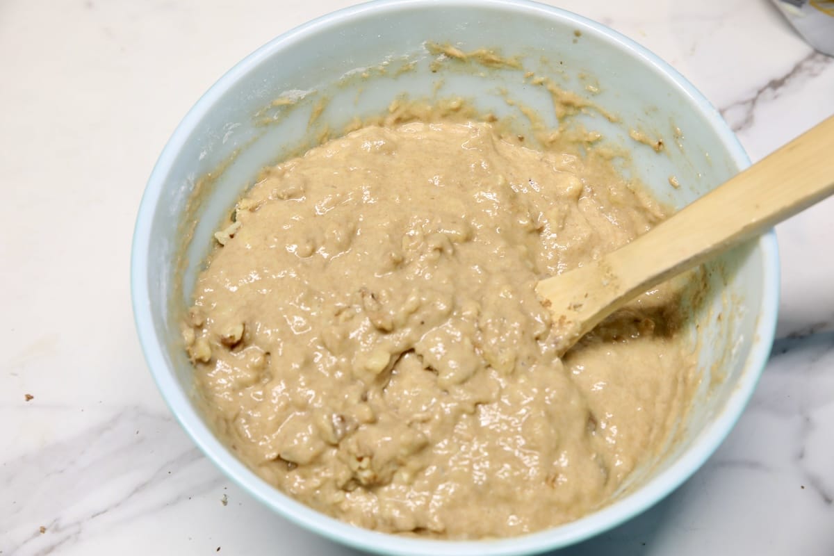 Bowl of banana bread mixture with spoon.