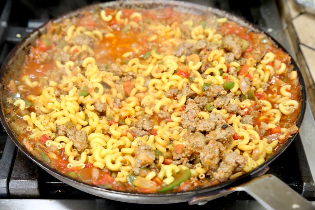Making goulash with tomatoes, macaroni.