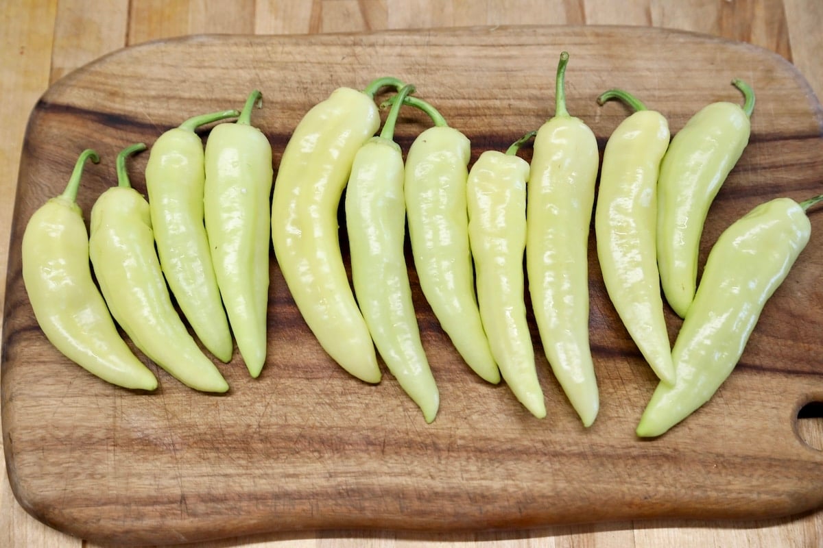 Banana peppers on a cutting board.