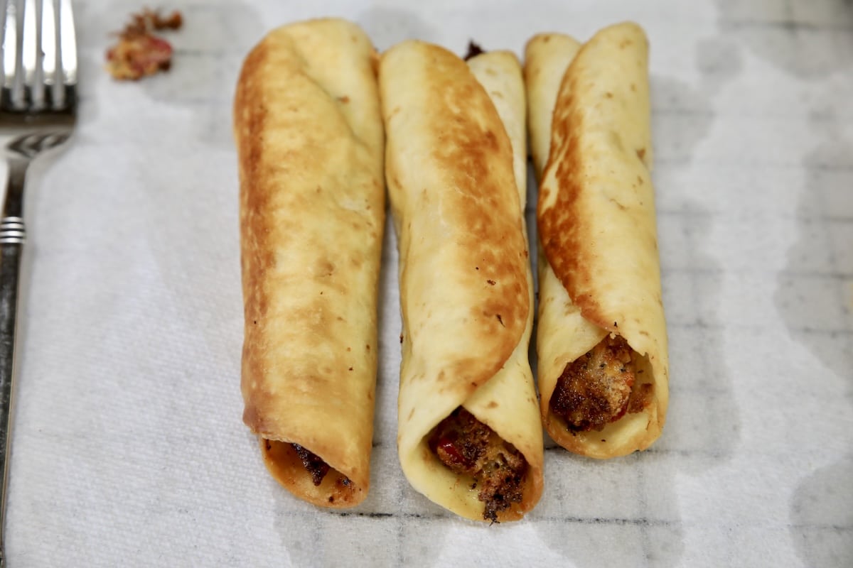 Fried taquitos on a paper towel.