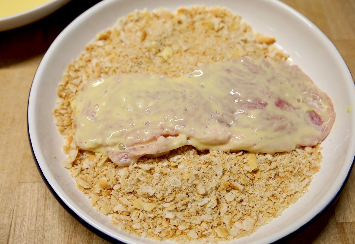 Breading pork chop in ritz cracker crumbs.
