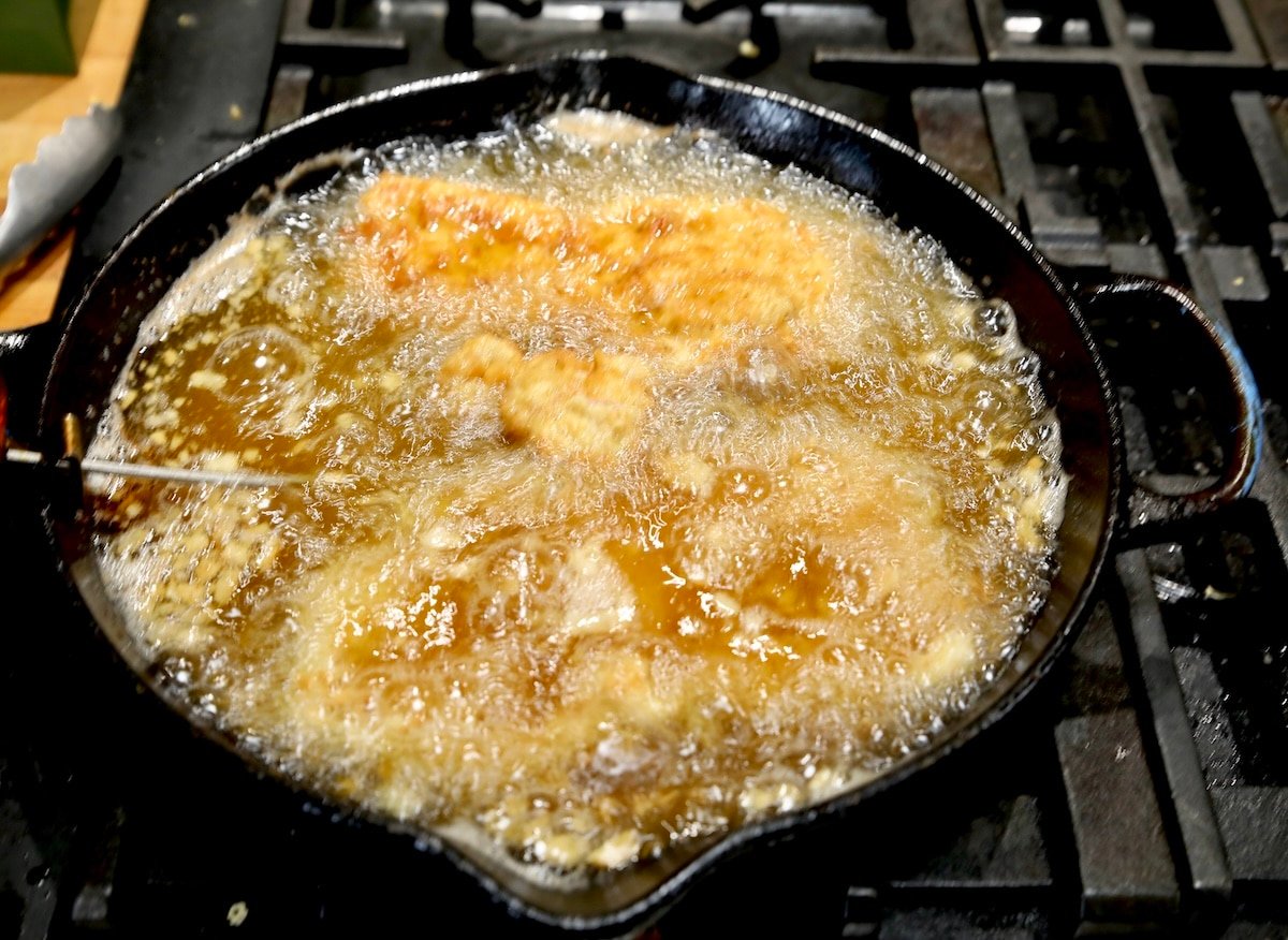 Frying breaded pork chops in a skillet.
