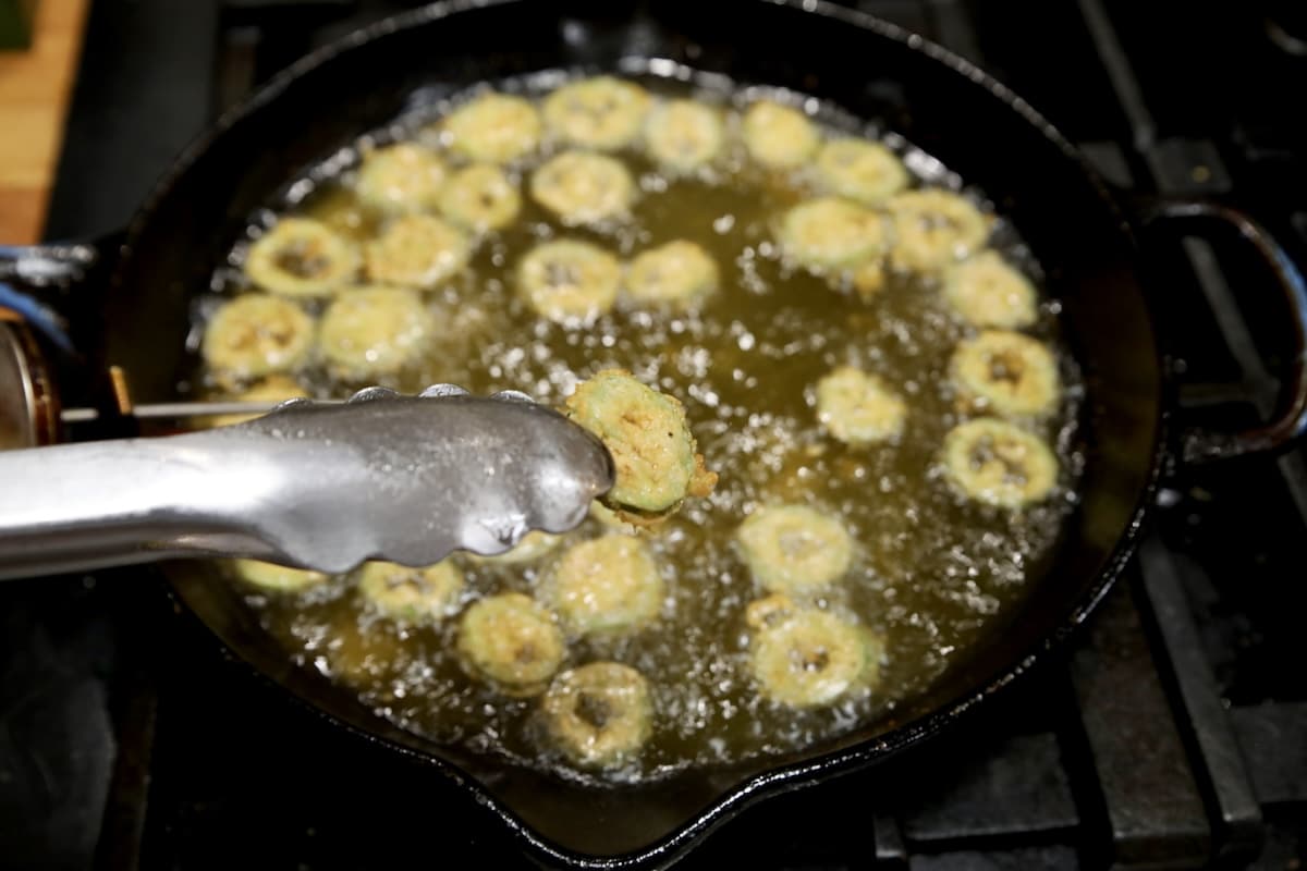 Frying jalapenos slices in a skillet.