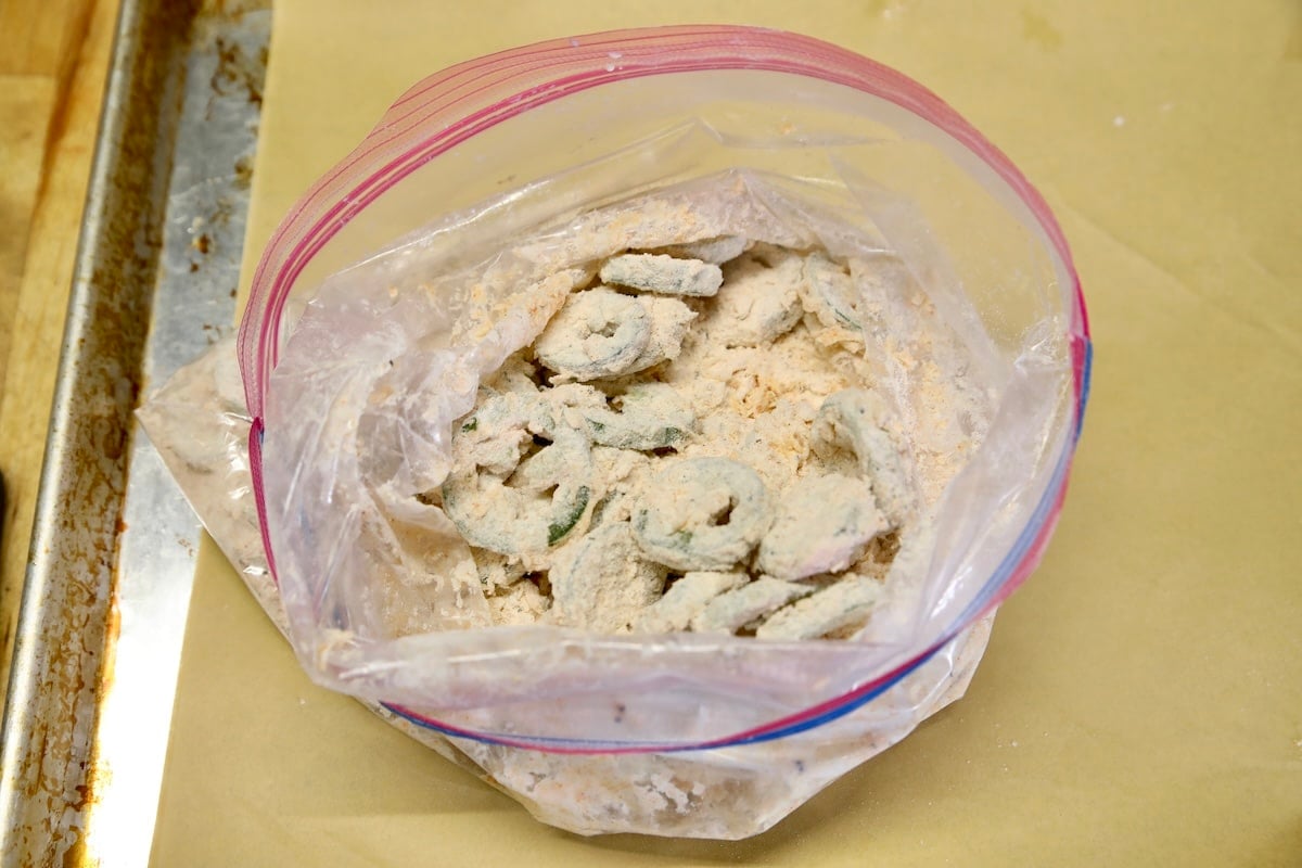 Flour coated jalapenos slices in ziploc bag.